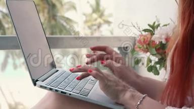 年轻女子在电脑上工作，在热带地区放松